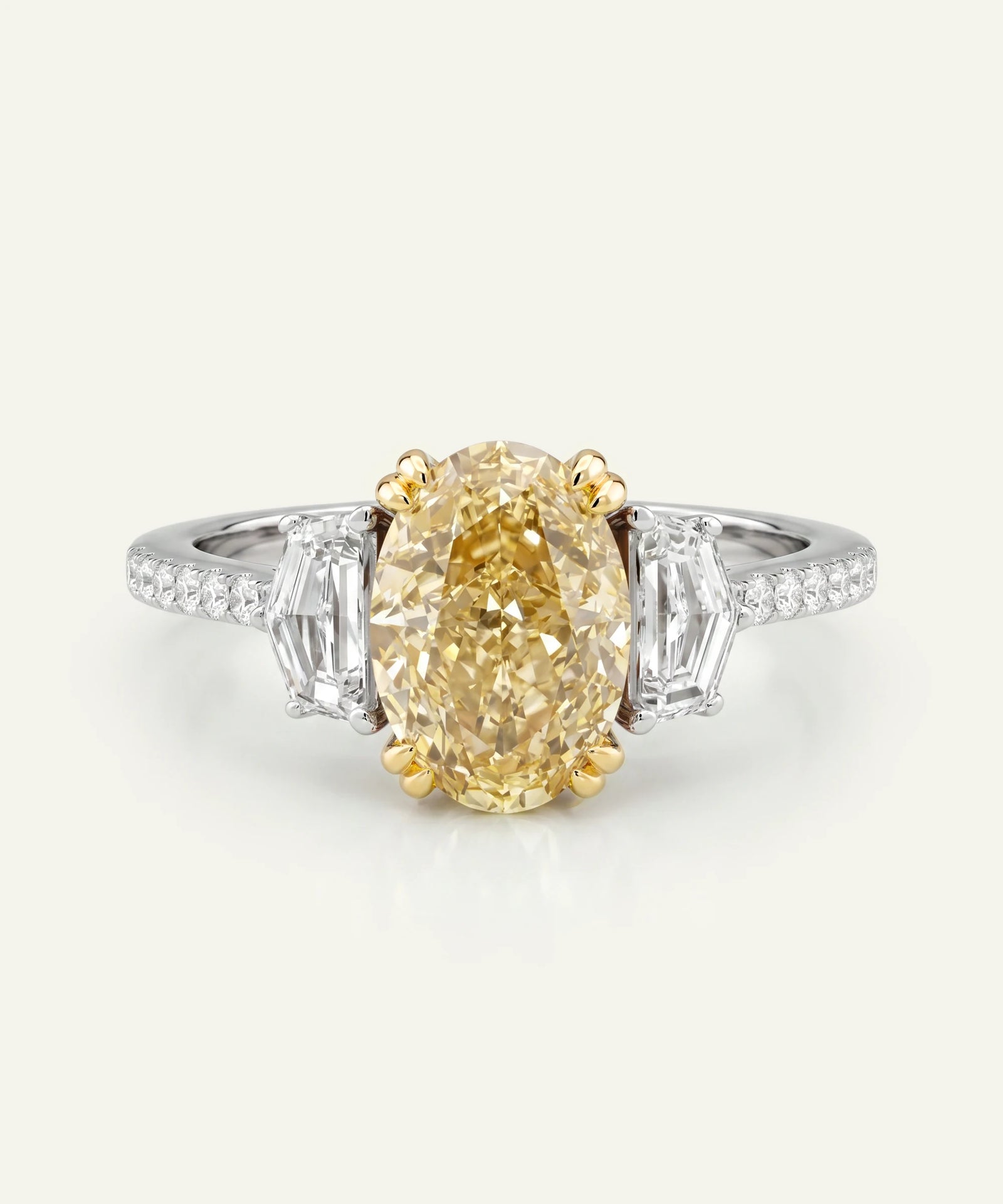 Diamond ring with a yellow diamond and baguette cut side stones on a white background