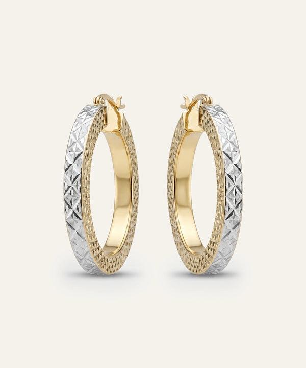 Gold and silver hoop earrings on a light beige background