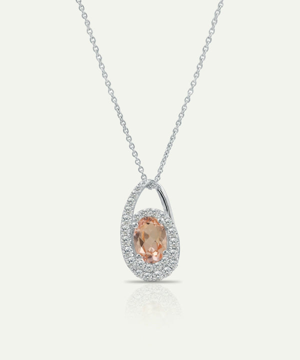 Silver necklace with a pendant featuring a peach-colored gemstone on a white background