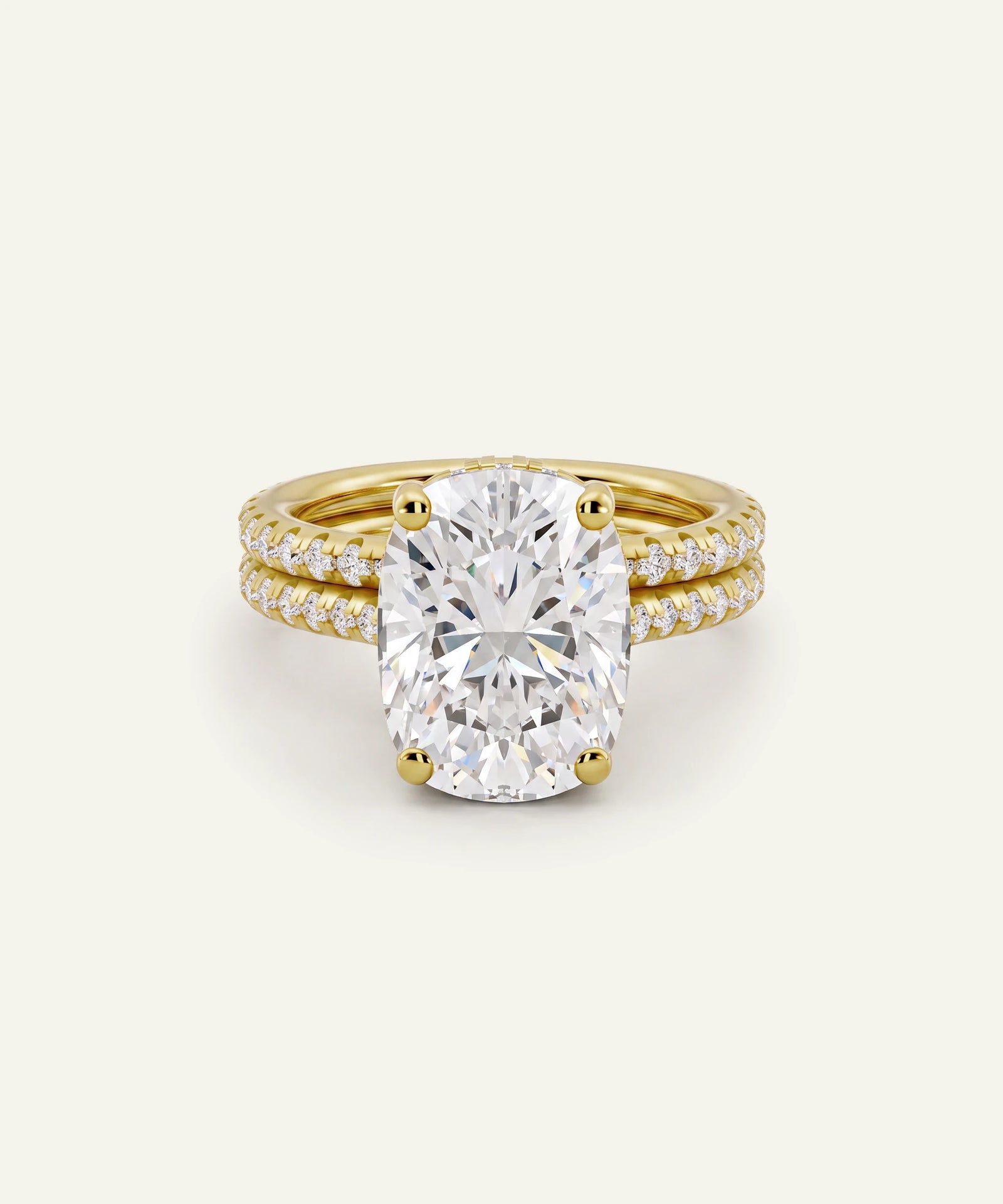 A yellow gold engagement ring featuring a large oval-cut diamond center stone, accented by a matching double-row diamond-paved band, set against a clean off-white background.