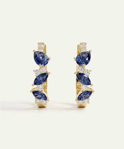 Pair of gold earrings with blue gemstones on a white background