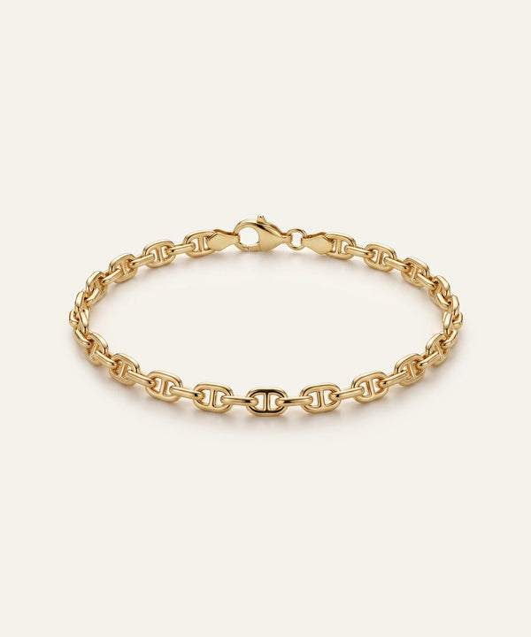 Gold chain bracelet on a light beige background