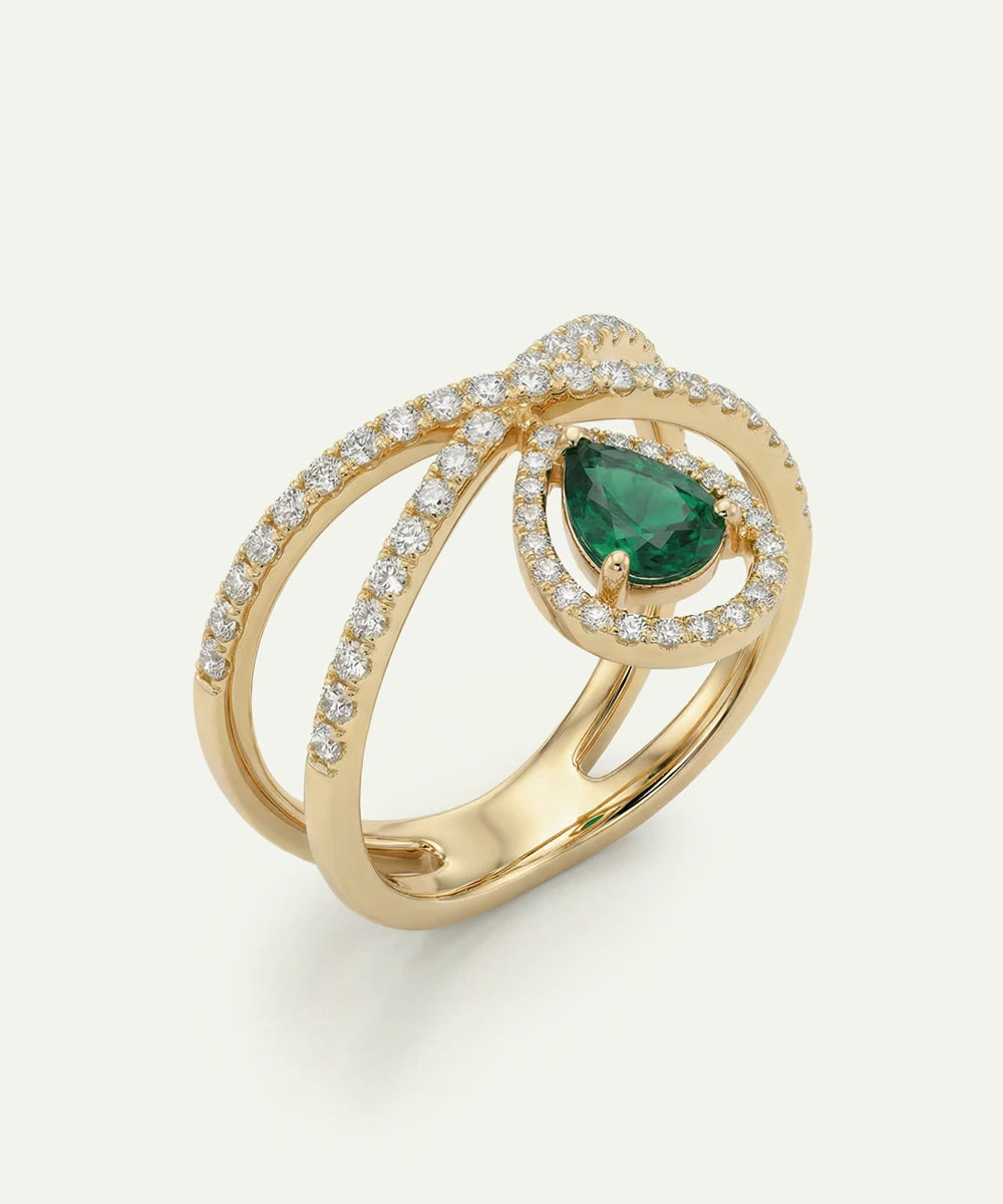 Gold ring with a green gemstone and diamond accents on a white background