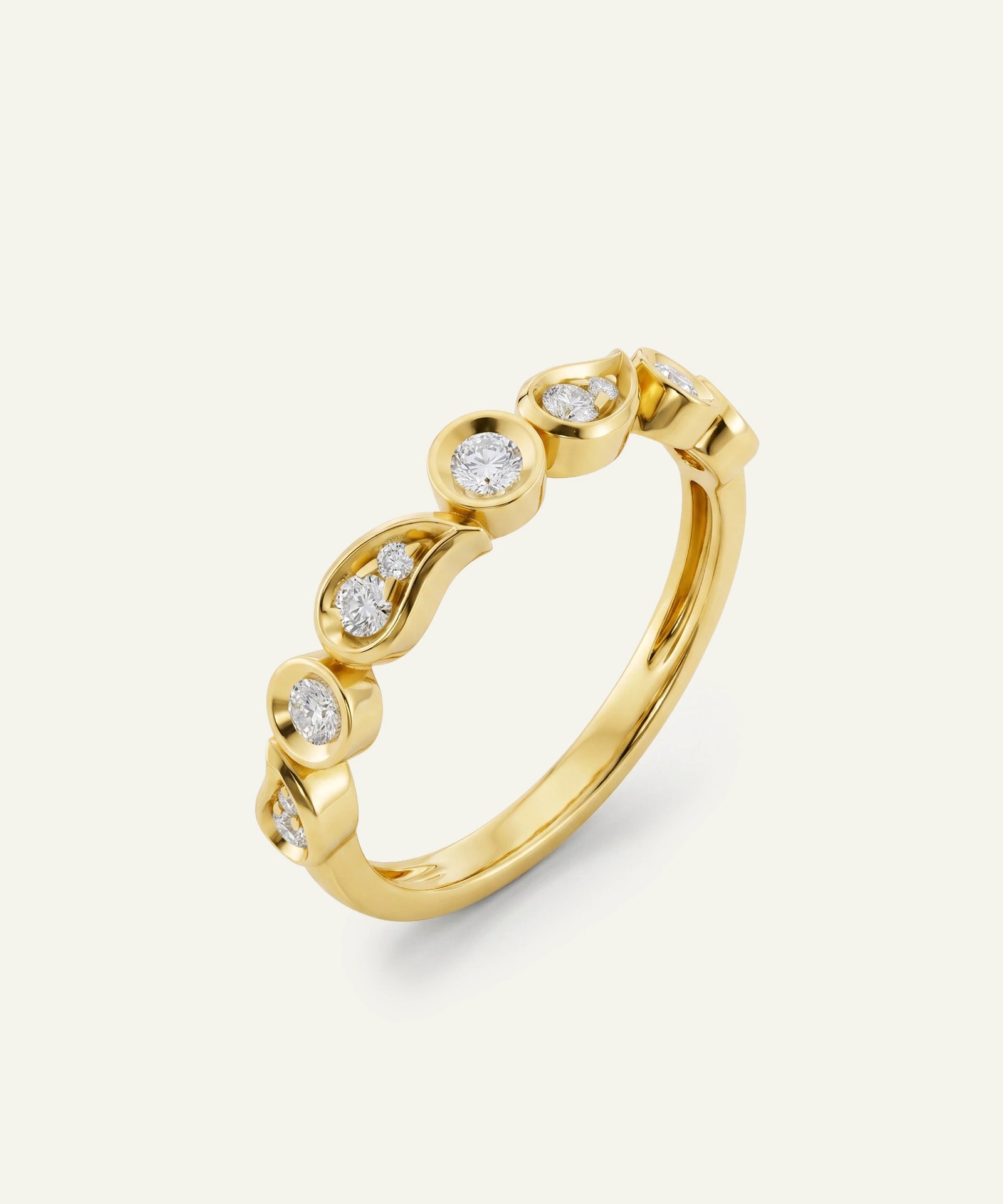 A yellow gold ring featuring a wavy, scalloped band with five small round-cut clear gemstones, set against a light off-white background.
