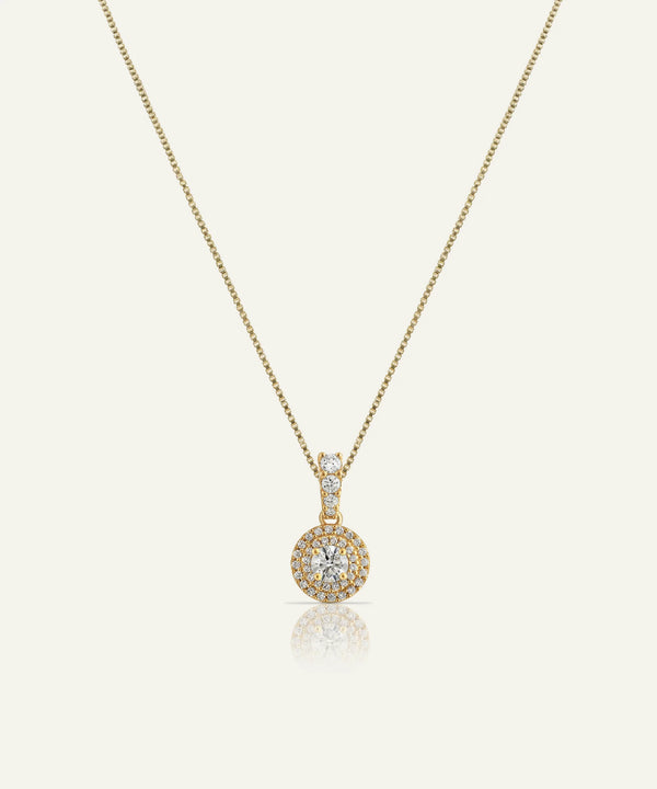 Gold necklace with a round pendant on a white background