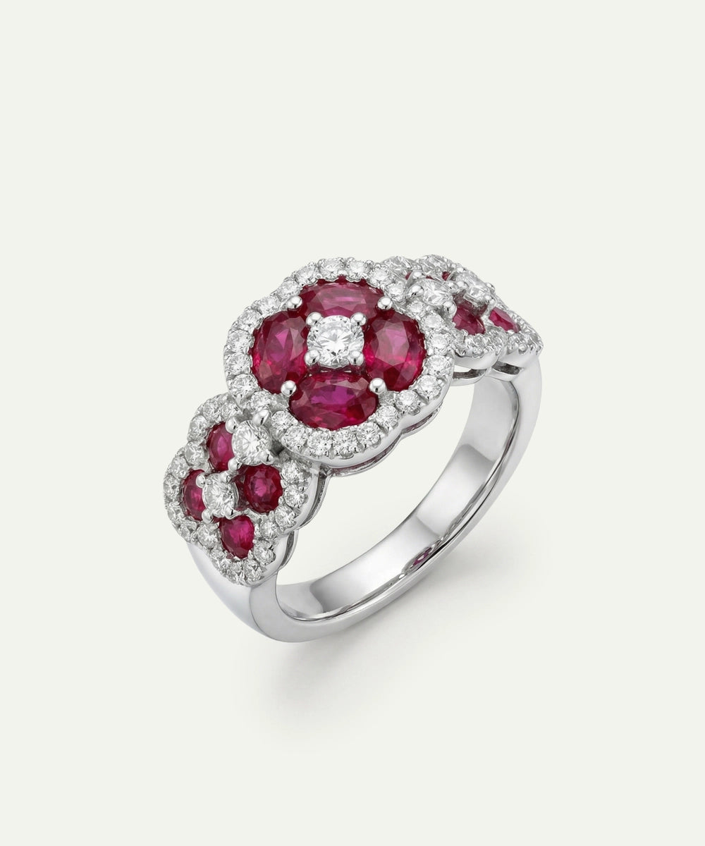 Silver ring with red gemstones and diamonds on a white background