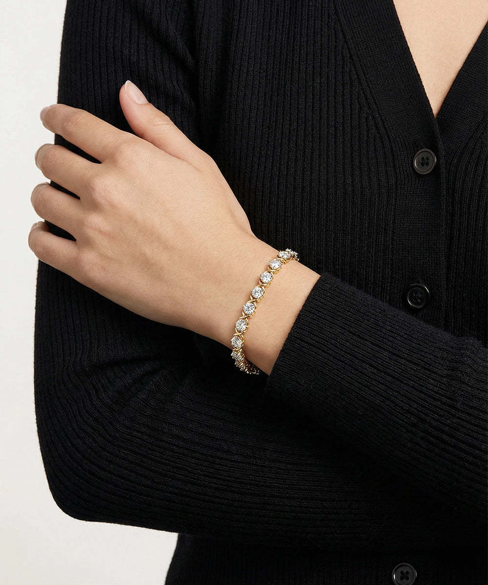 Person wearing a silver bracelet on a plain background