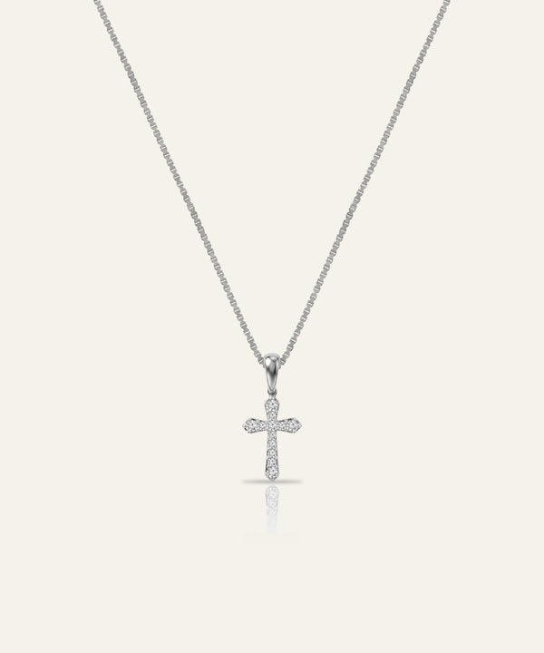 Silver cross pendant necklace on a light gray background
