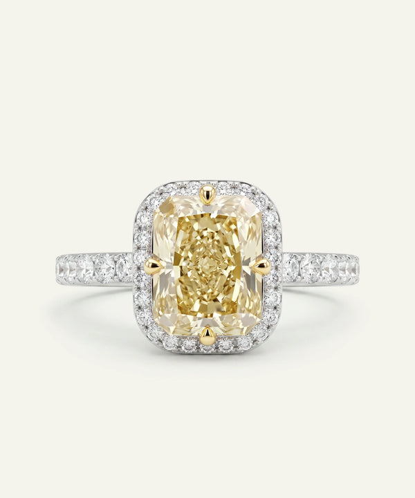 Diamond ring with a yellow gemstone on a light gray background