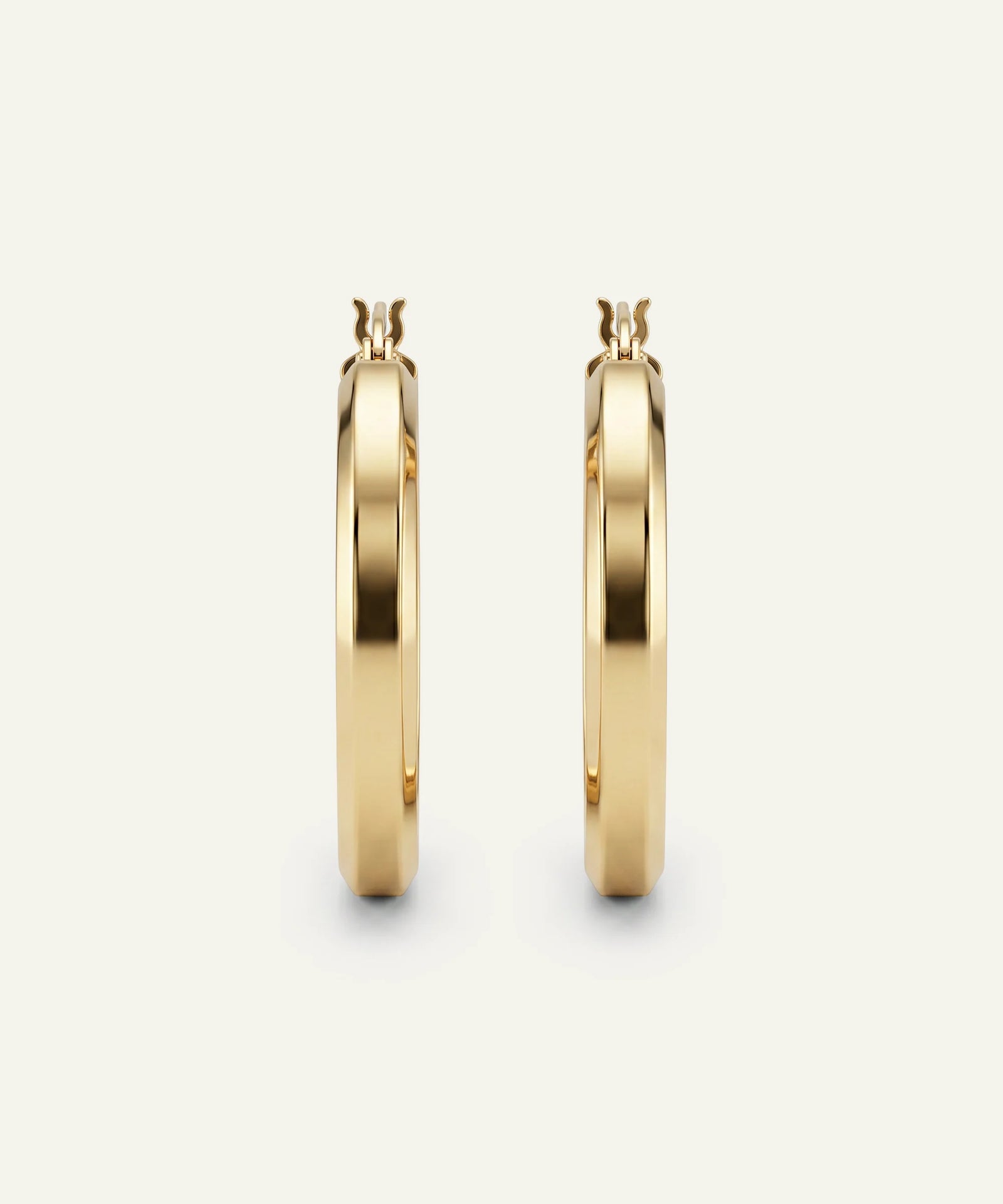 Gold hoop earrings on a light beige background