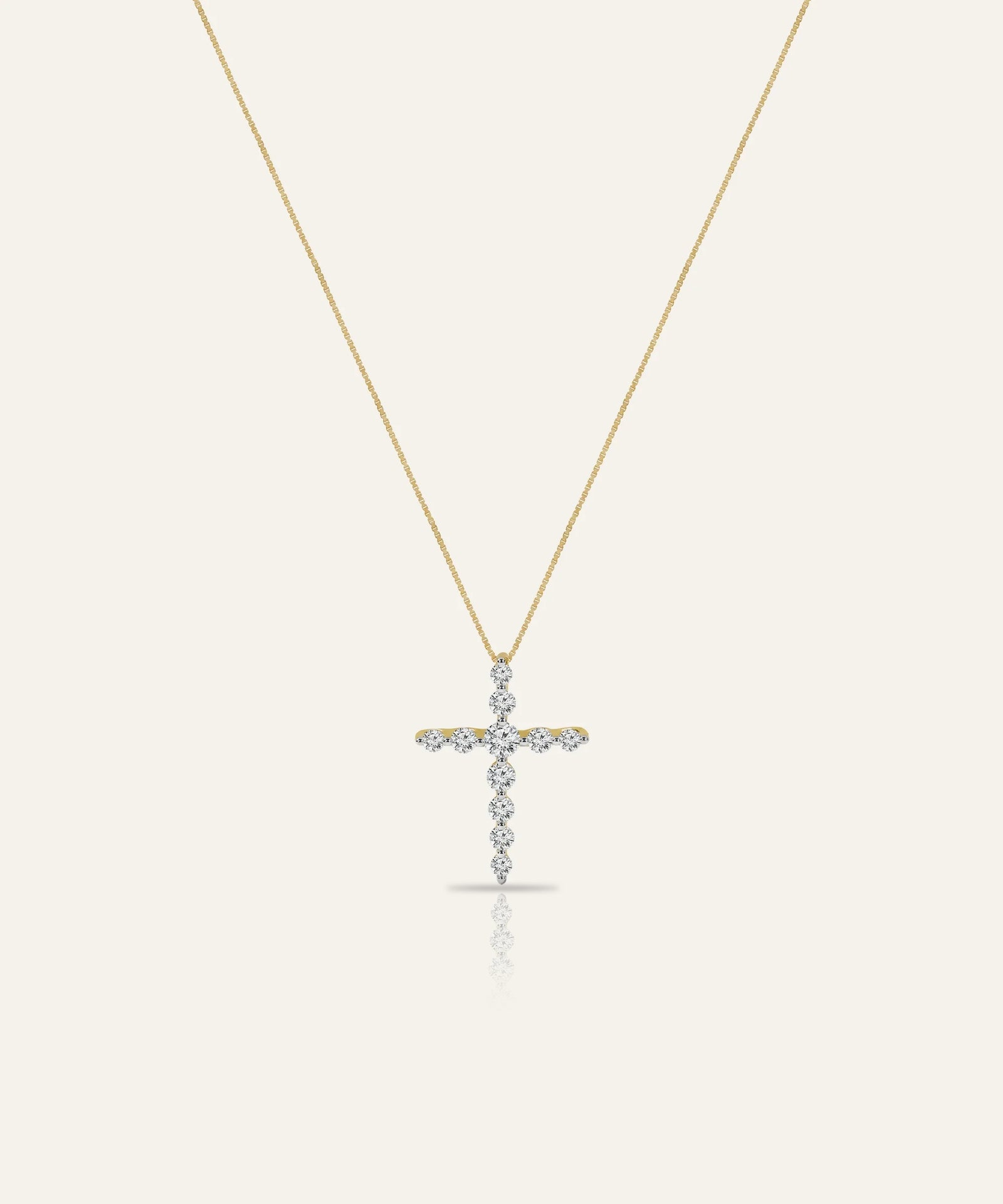Gold cross necklace with diamonds on a white background