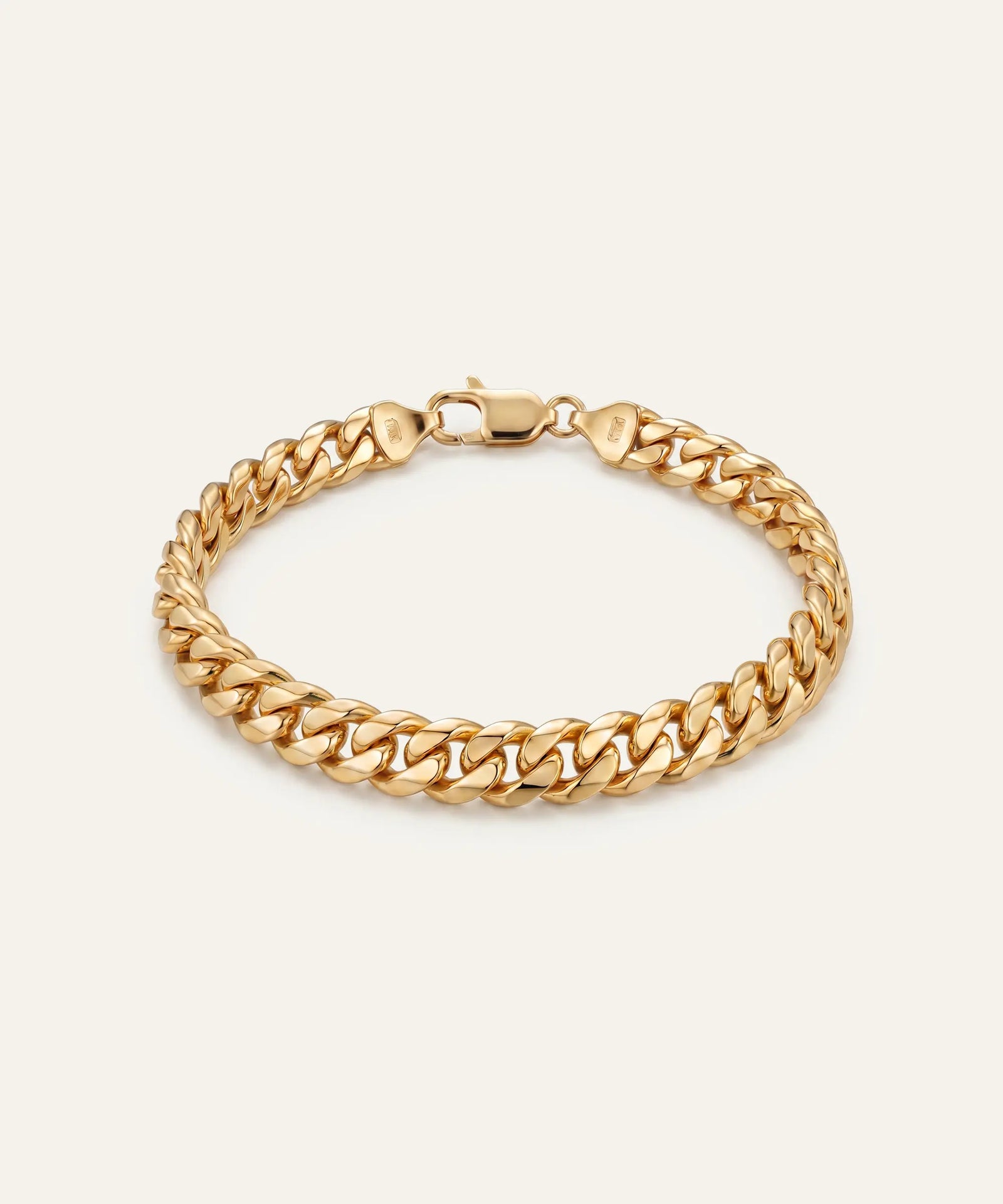 Gold chain bracelet on a beige background