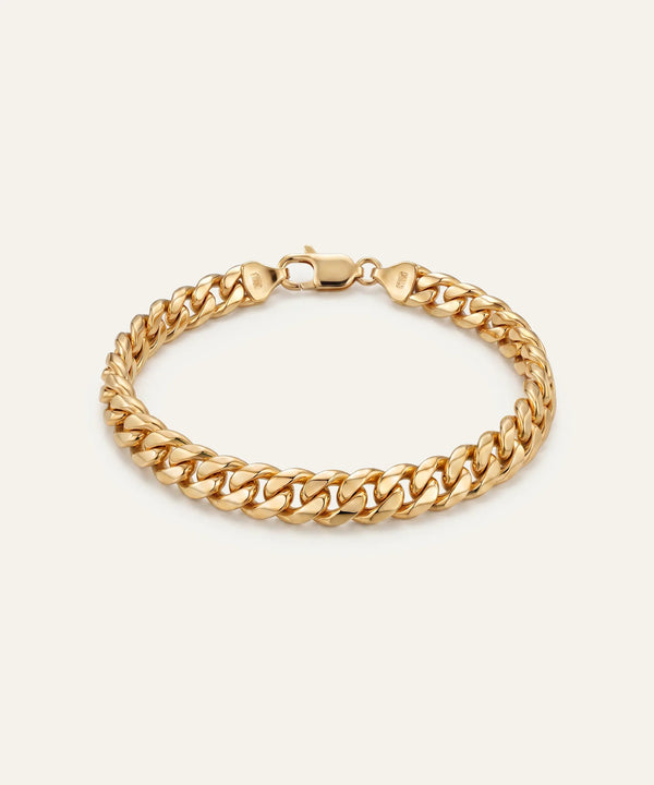 Gold chain bracelet on a beige background