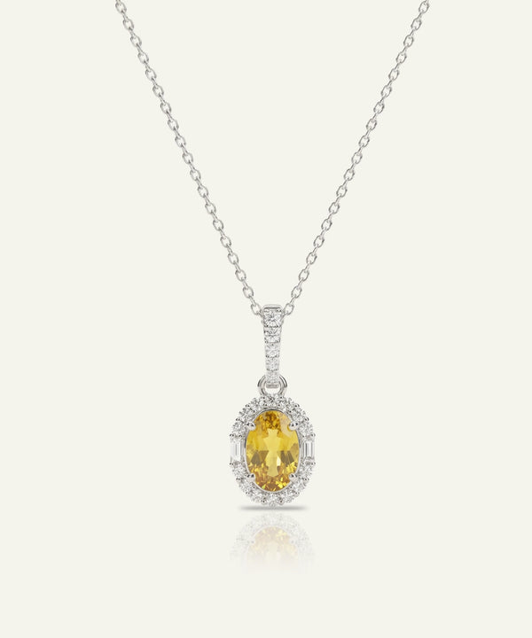 Silver necklace with a yellow gemstone pendant on a white background