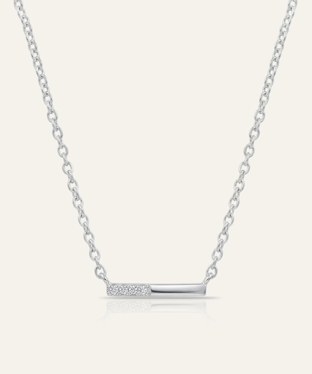 Silver necklace with a bar pendant on a light gray background