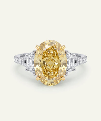 Gold ring with a large yellow gemstone on a white background