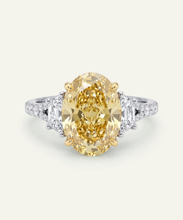 Gold ring with a large yellow gemstone on a white background