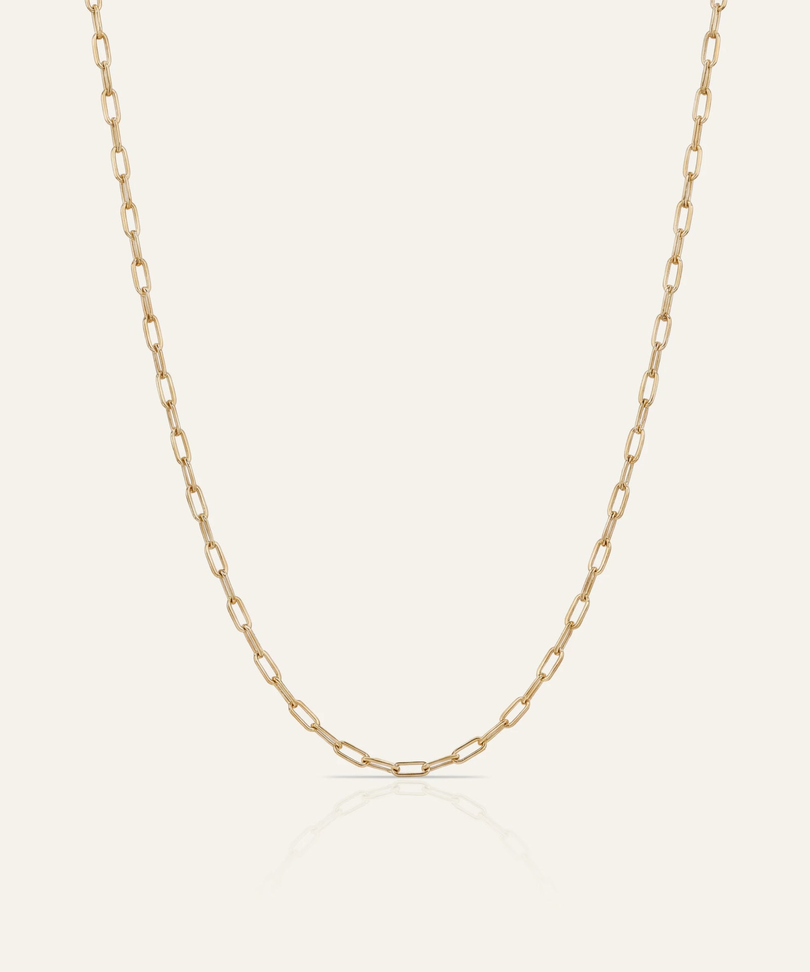 Gold chain necklace on a light beige background