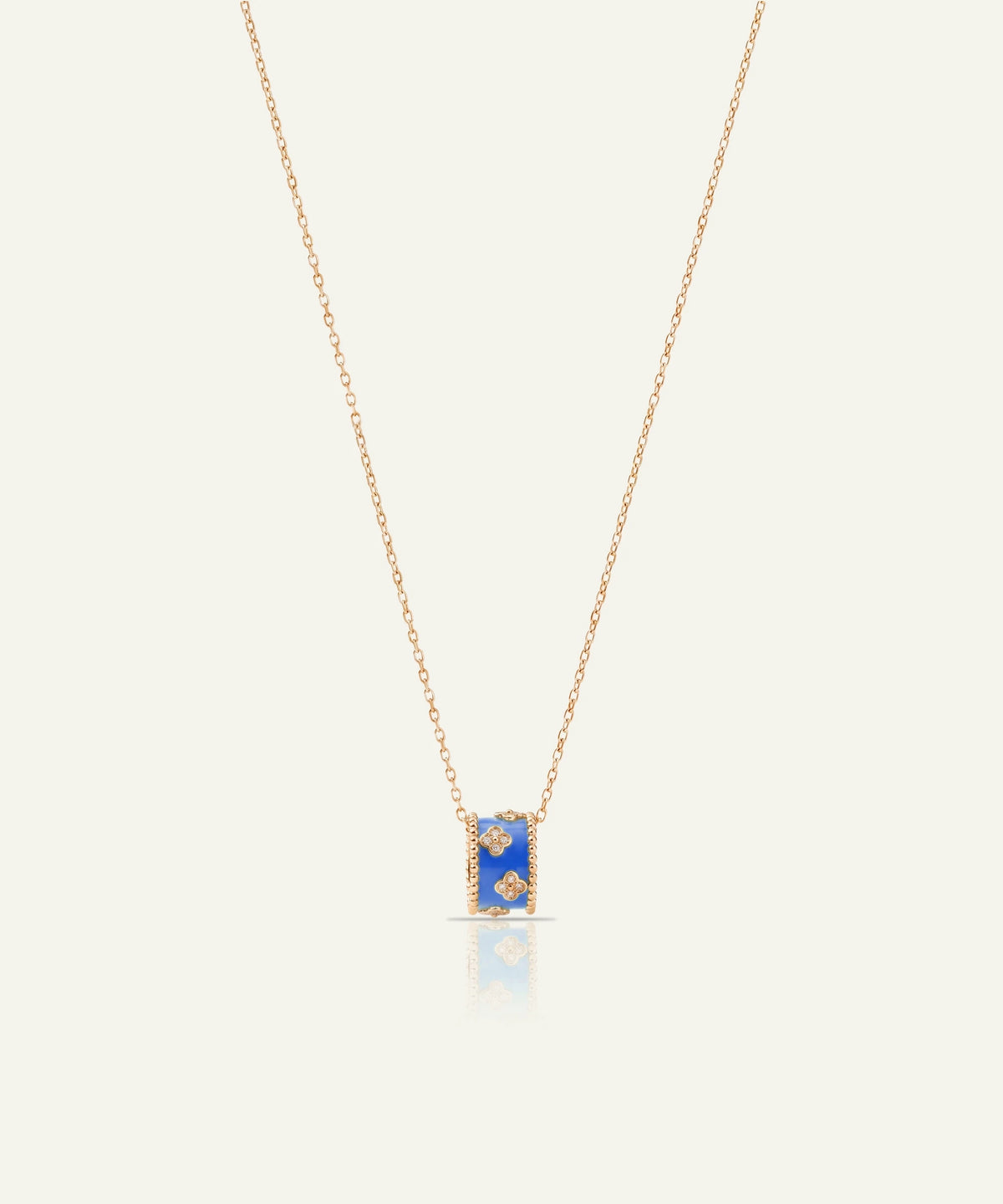 Gold chain necklace with a blue rectangular pendant featuring floral details and clear accent stones.