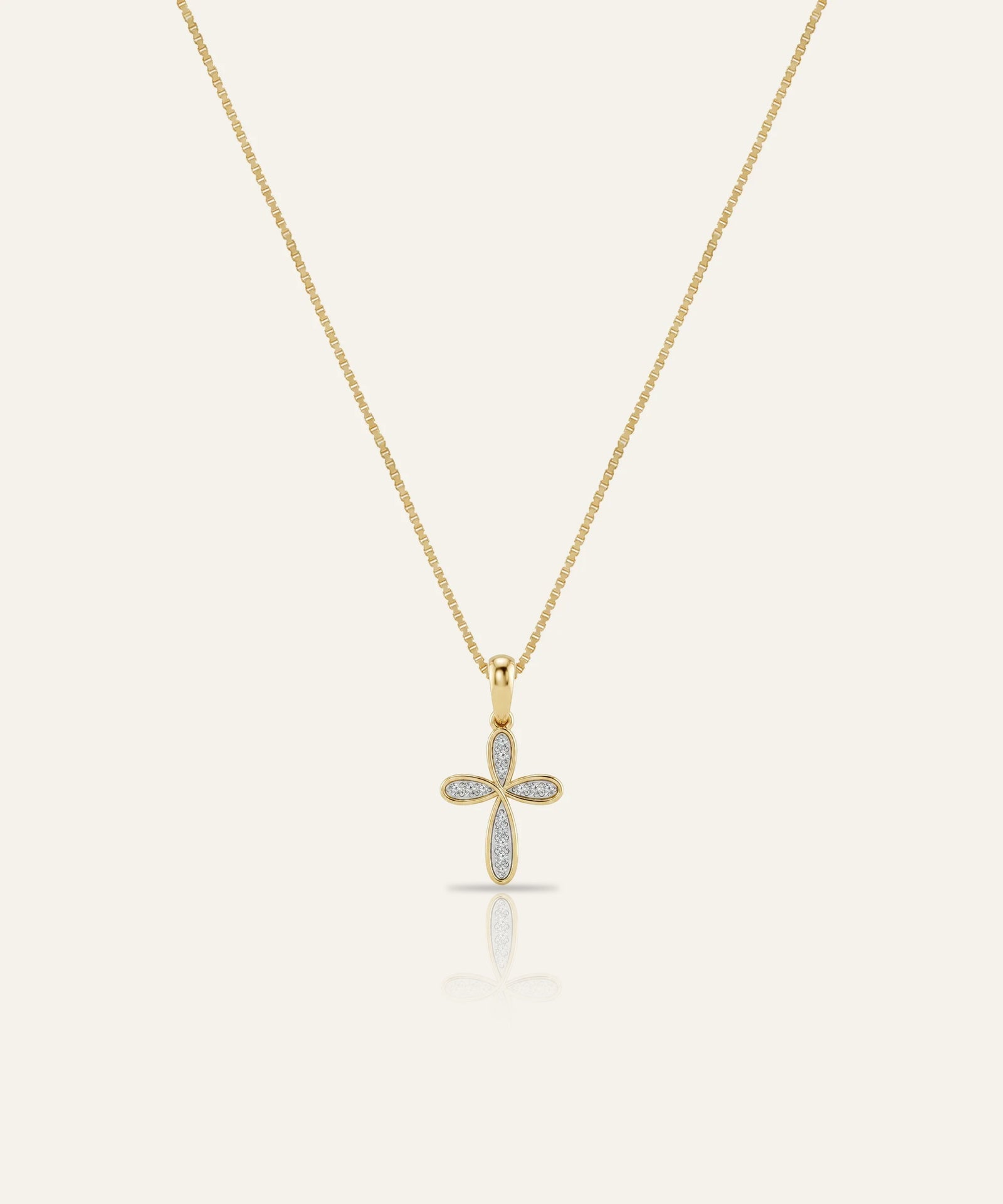 Gold cross necklace with diamonds on a white background