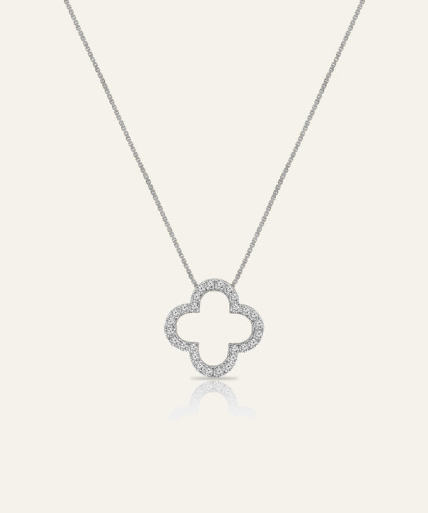 Silver necklace with a clover-shaped pendant on a light gray background
