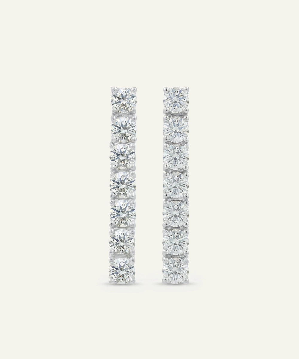 Pair of diamond earrings on a light gray background