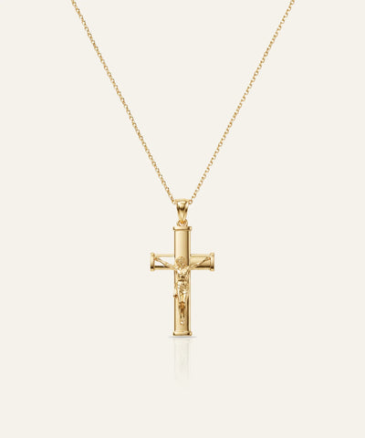 Gold cross pendant necklace on a white background