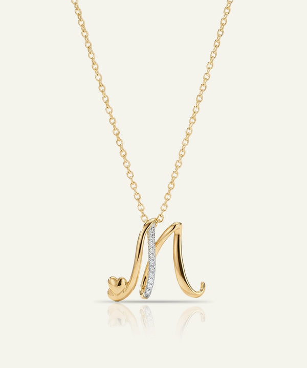 Gold necklace with a letter 'M' pendant on a white background