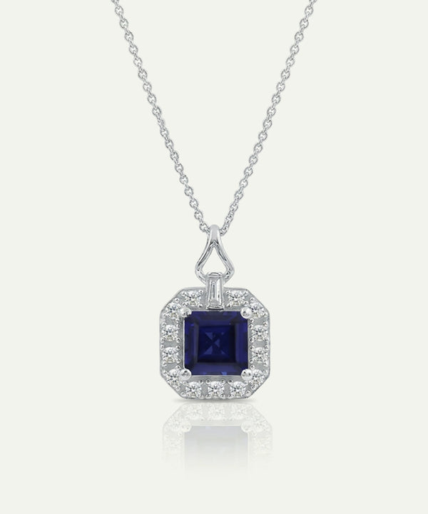Silver necklace with a blue gemstone pendant on a white background