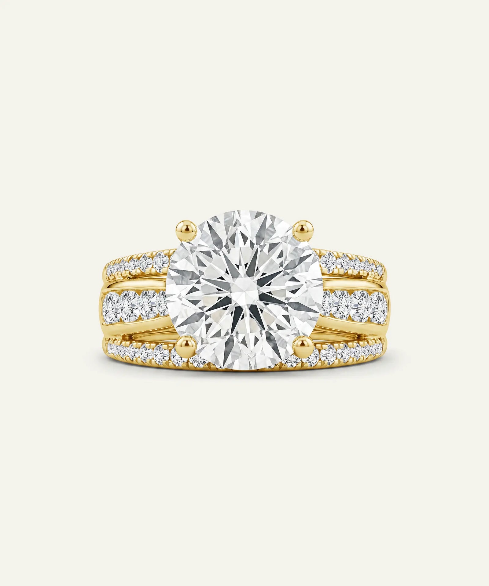 A yellow gold ring set featuring a large round brilliant-cut center stone and matching pavé-set accent stones on a slim band, shown on a light cream background.