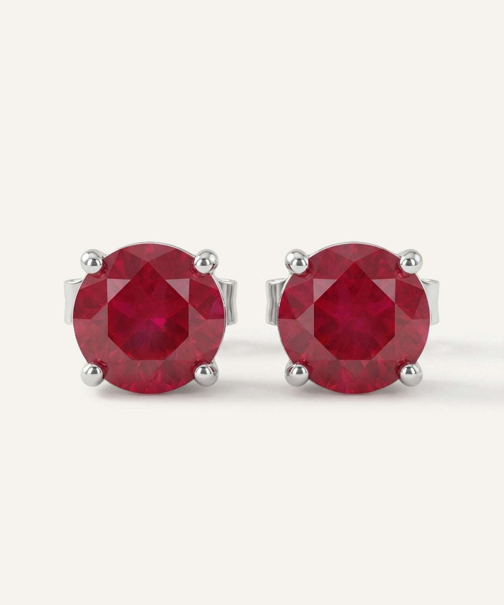 Pair of red gemstone stud earrings on a white background