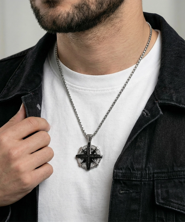 Man wearing a black necklace with a pendant on a plain background