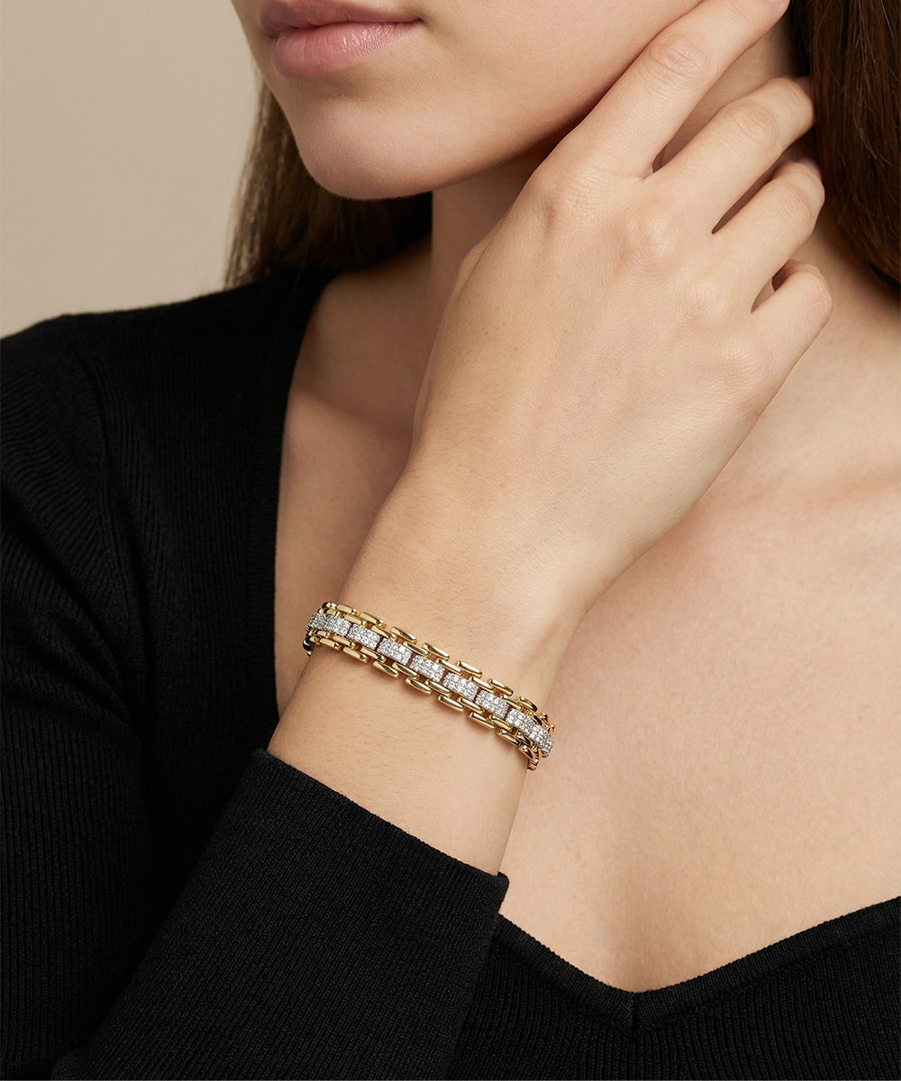 Close-up of a person wearing a diamond bracelet on a neutral background