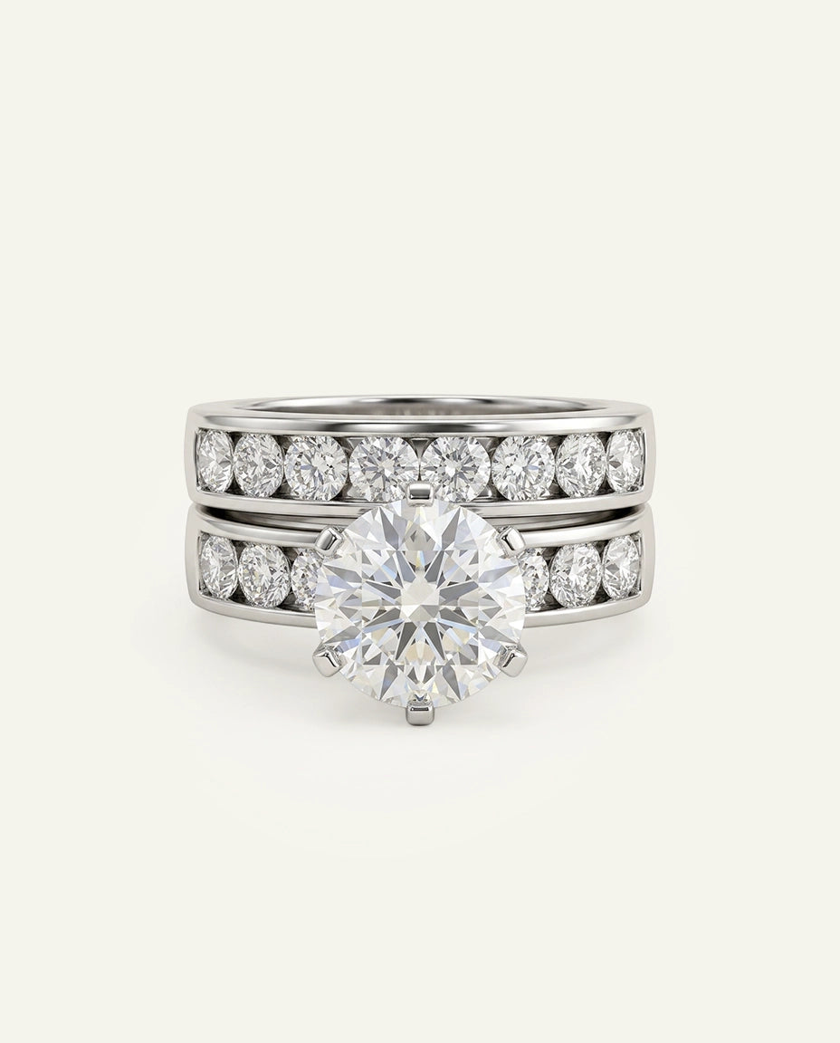 A silver-toned engagement ring set with a large round-cut center stone and a matching diamond band, photographed on a clean off-white background.