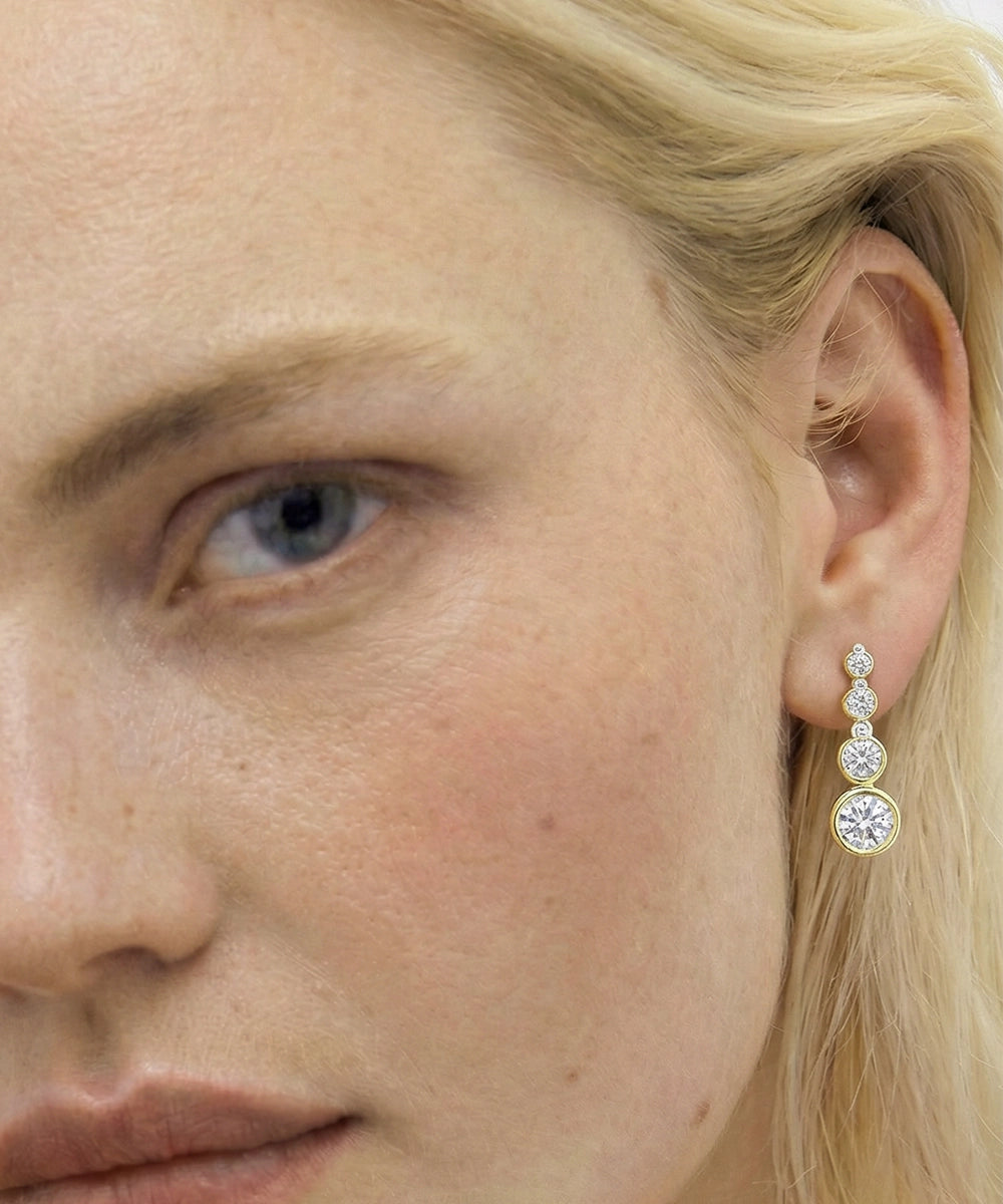 Close-up of a woman wearing a diamond earring.