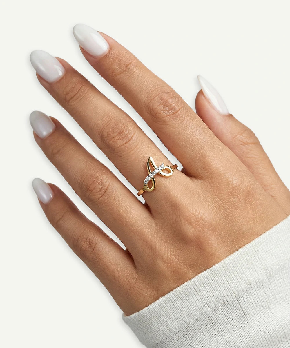 Hand wearing a gold ring with a white background