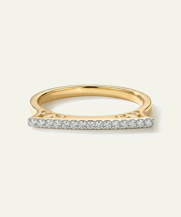 Gold ring with small diamonds on a light beige background