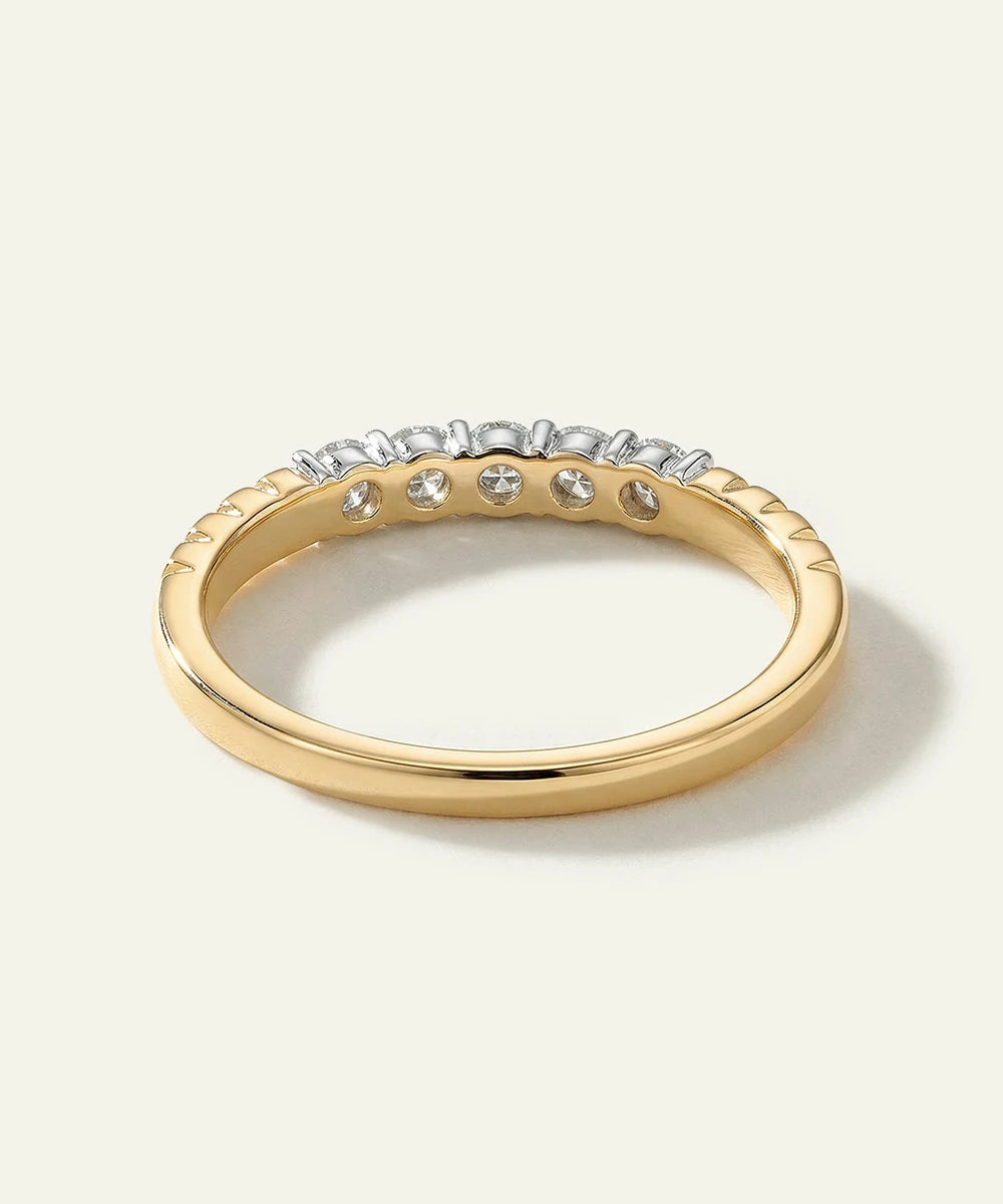 Gold ring with embedded diamonds on a light background