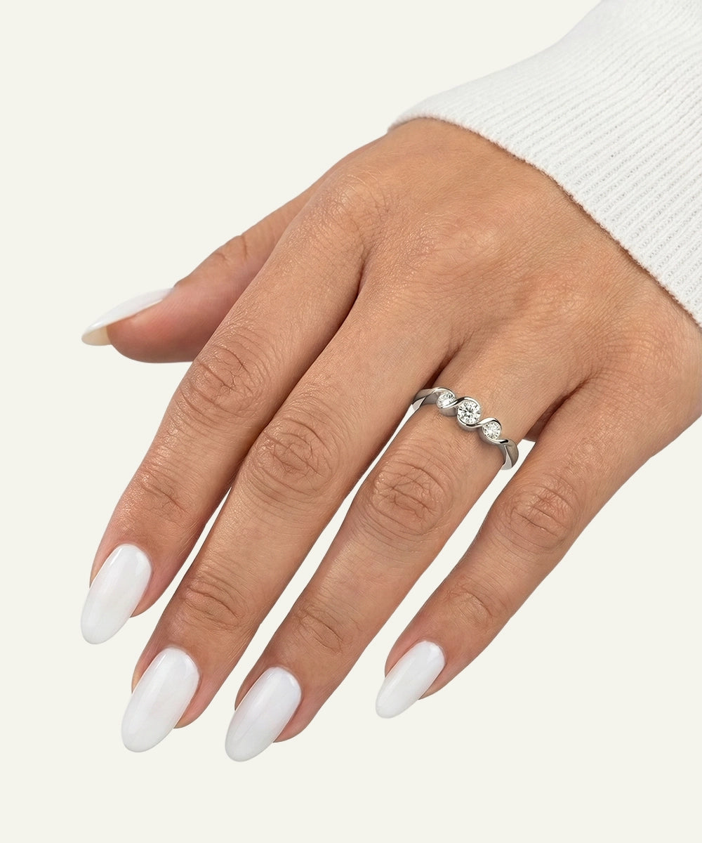 Hand wearing a silver ring with a white background