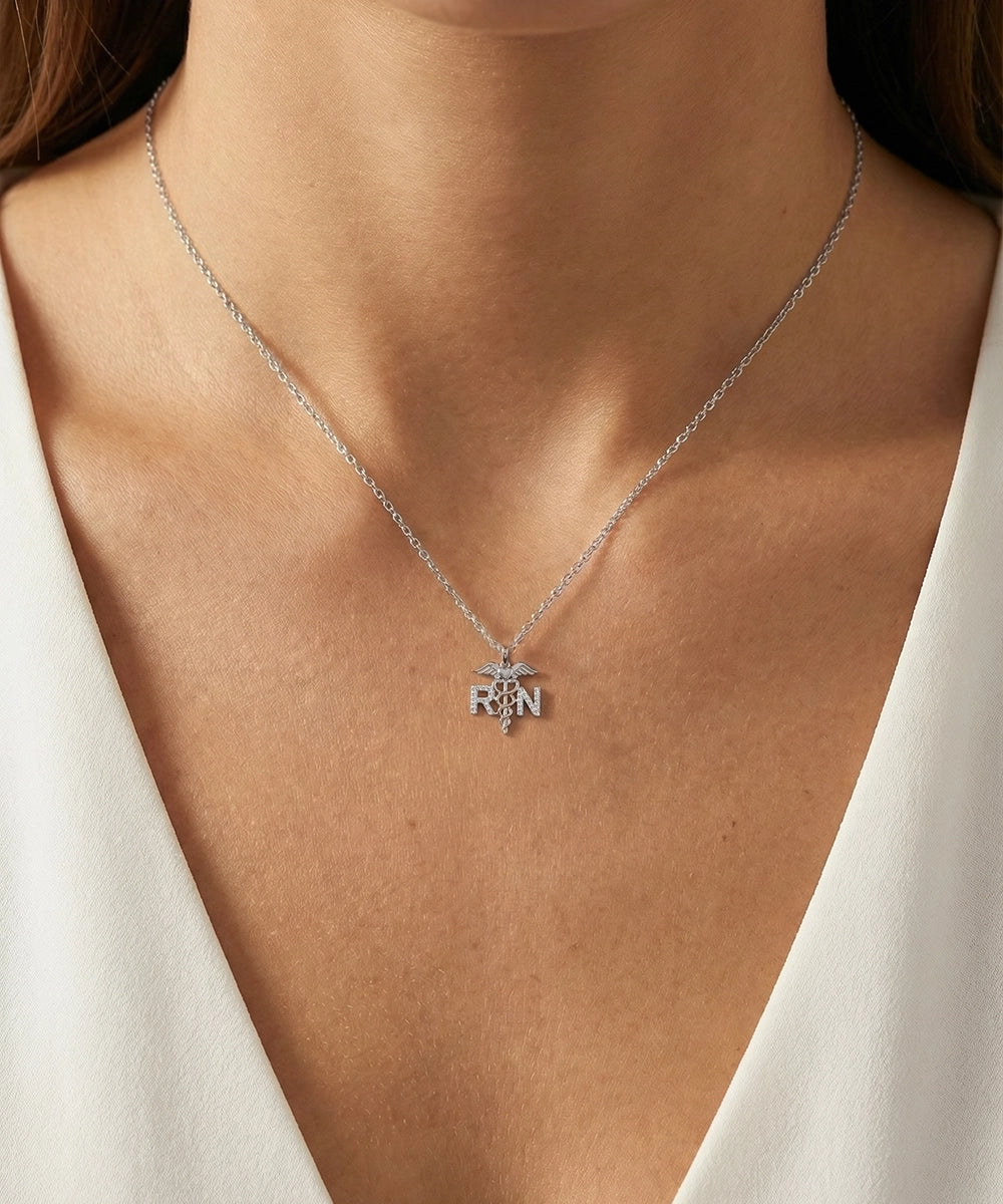 Silver necklace with a pendant worn by a person against a neutral background