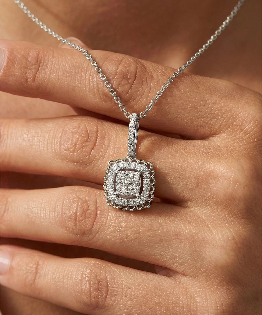 Silver necklace with a diamond pendant held in a hand