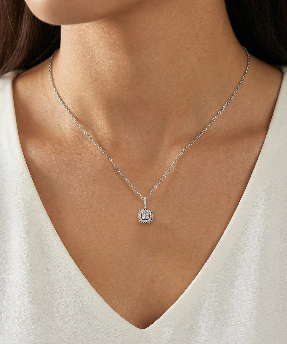 Necklace with a pendant worn by a person in a white top