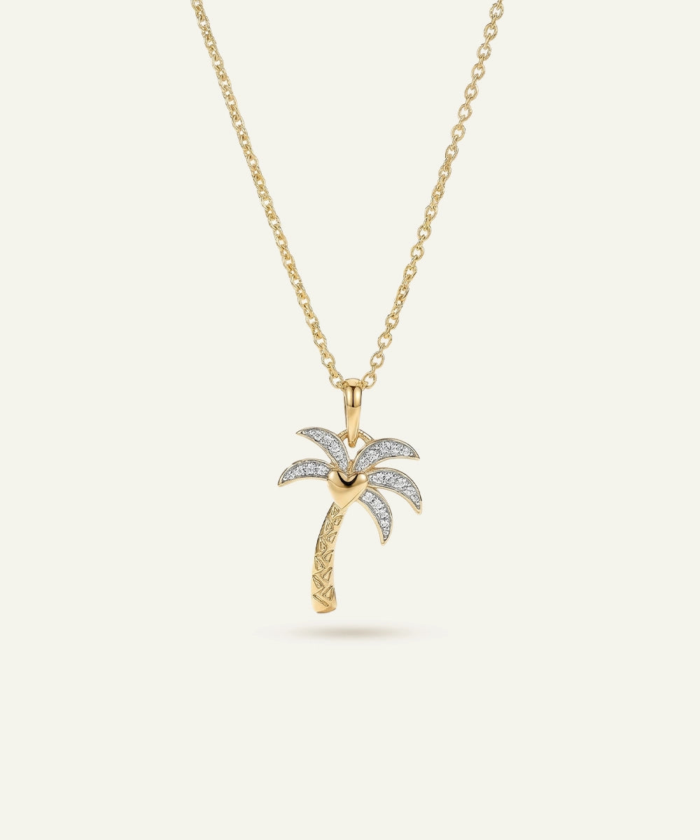 Gold palm tree pendant necklace on a white background