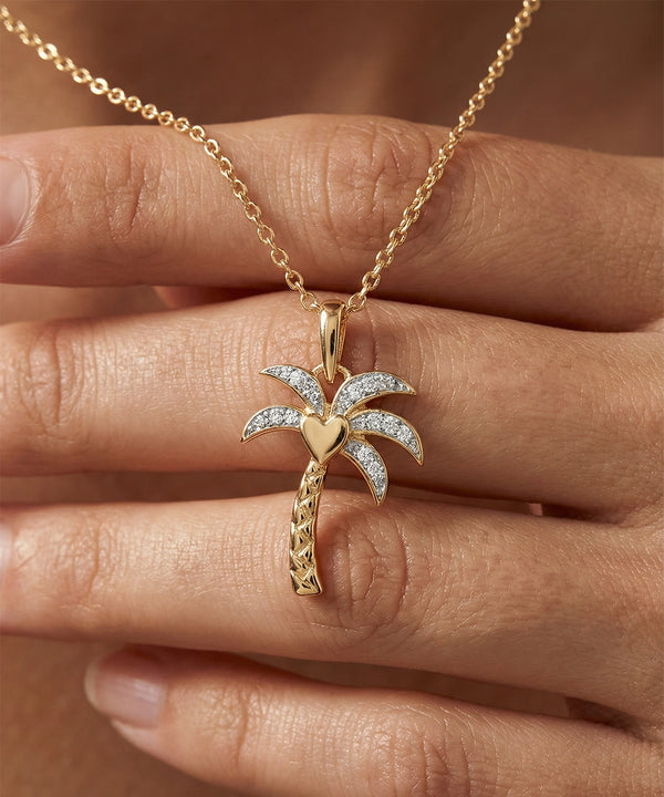 Gold palm tree necklace with diamonds on a hand