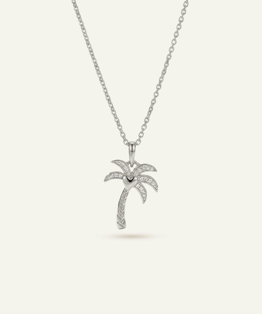 Silver palm tree pendant necklace on a white background