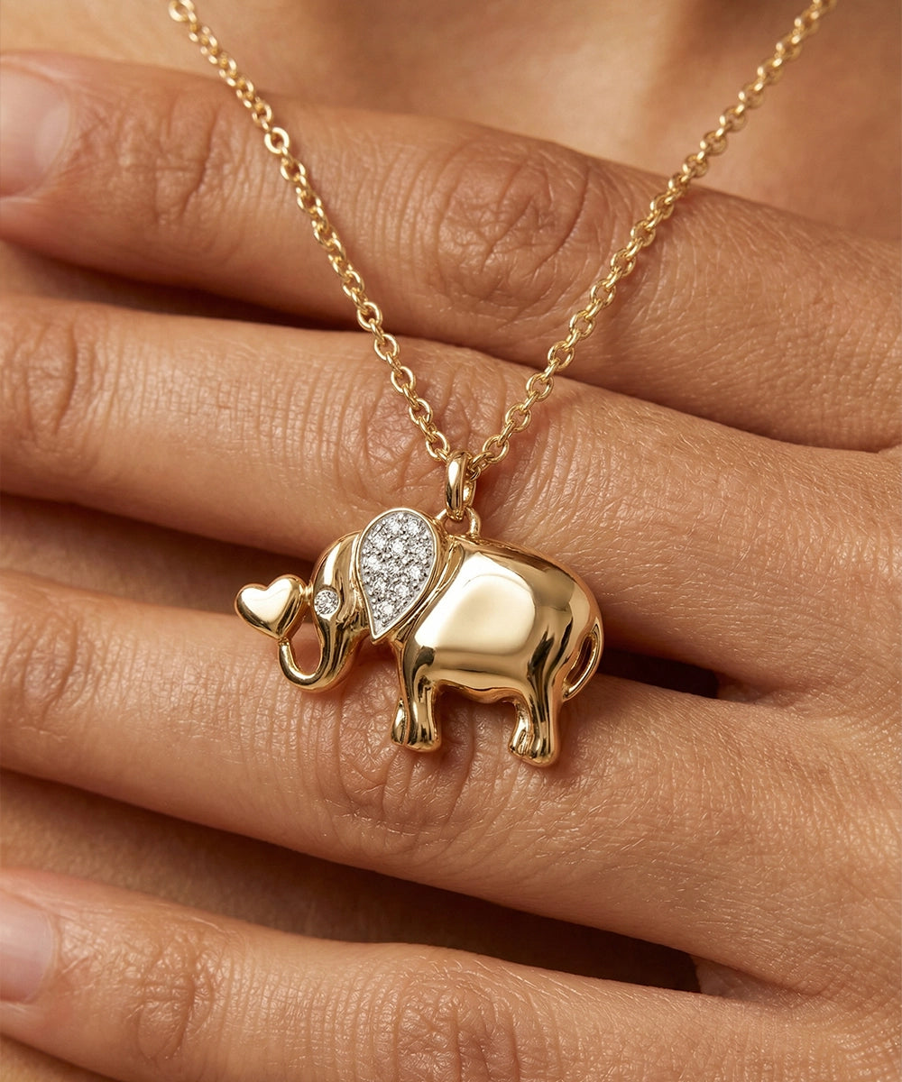 Gold elephant pendant necklace on a hand