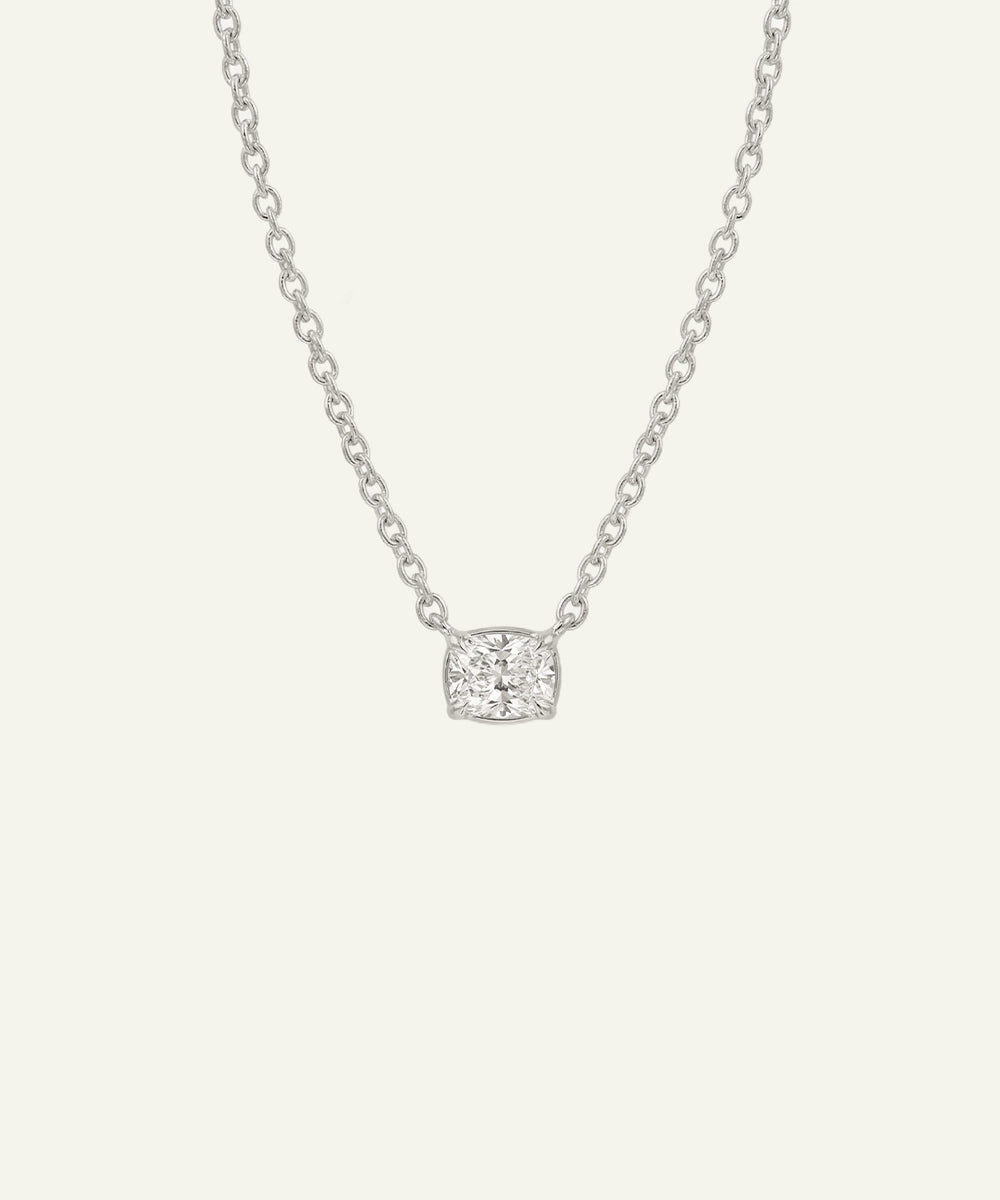Silver necklace with a square pendant on a light gray background