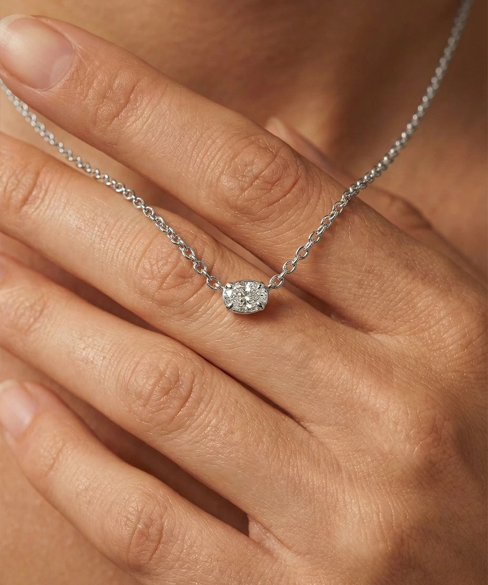 Silver necklace with a diamond pendant on a hand