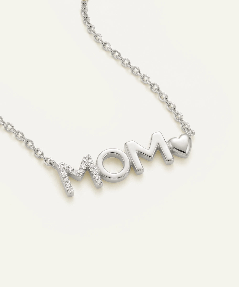 Silver 'MOM' necklace with a heart on a white background