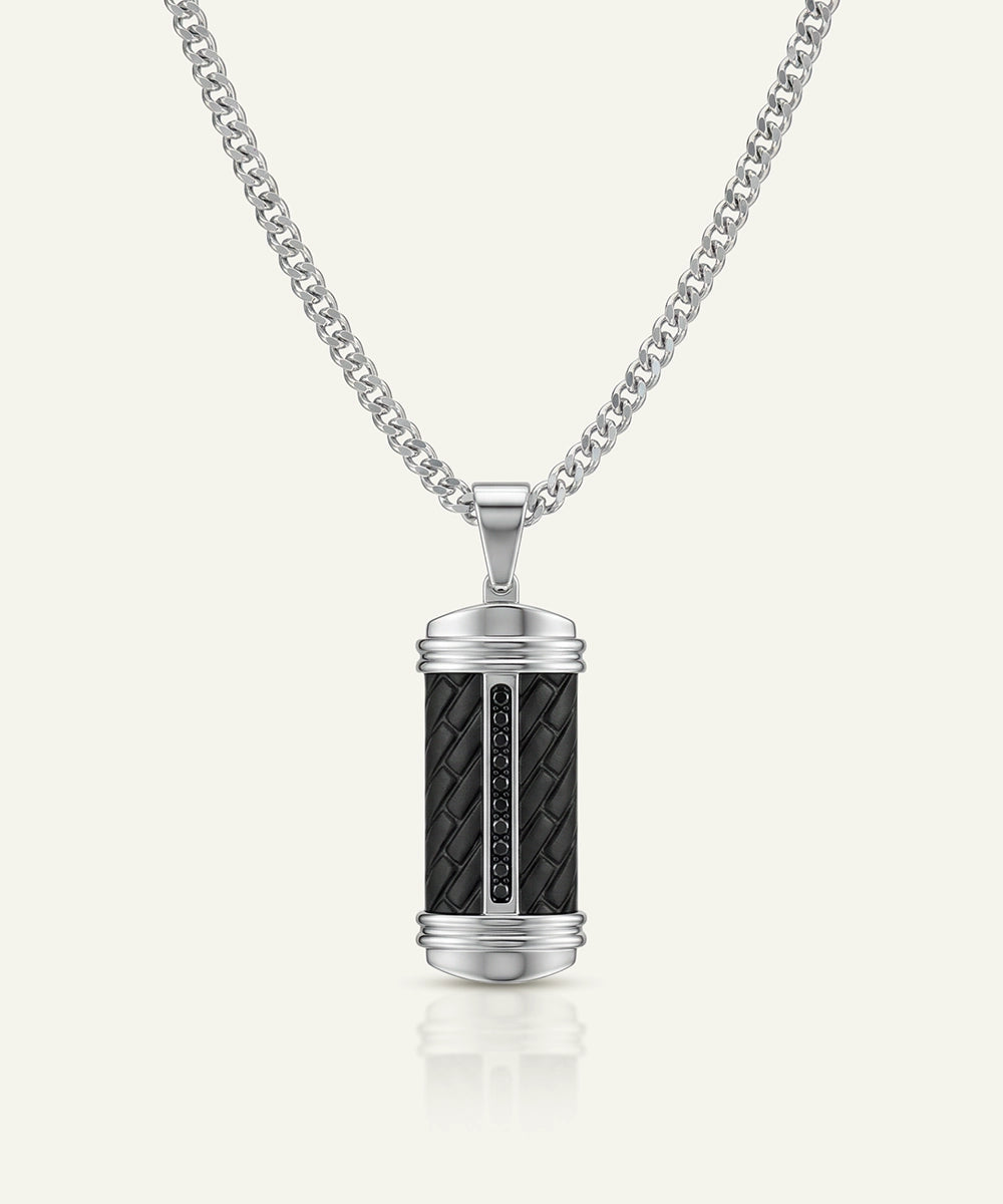 Silver pendant with black woven design on a white background